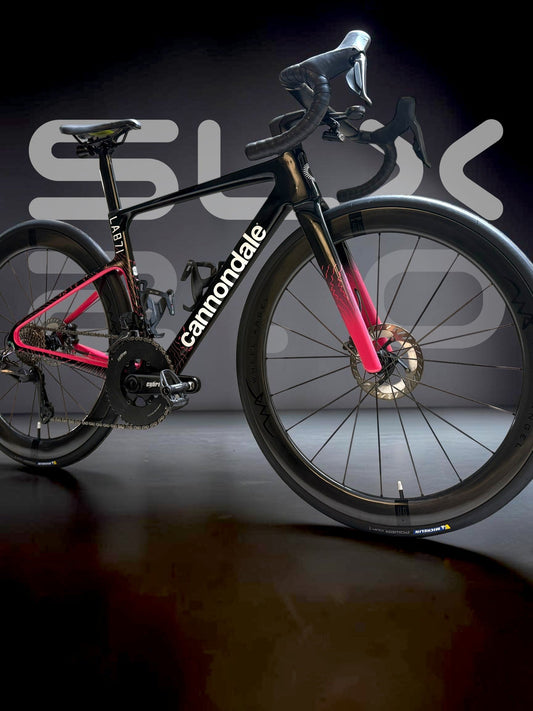 Side profile of a black and pink Cannondale road bike equipped with Wheel Angel SLX 2.0 deep-section carbon wheels.